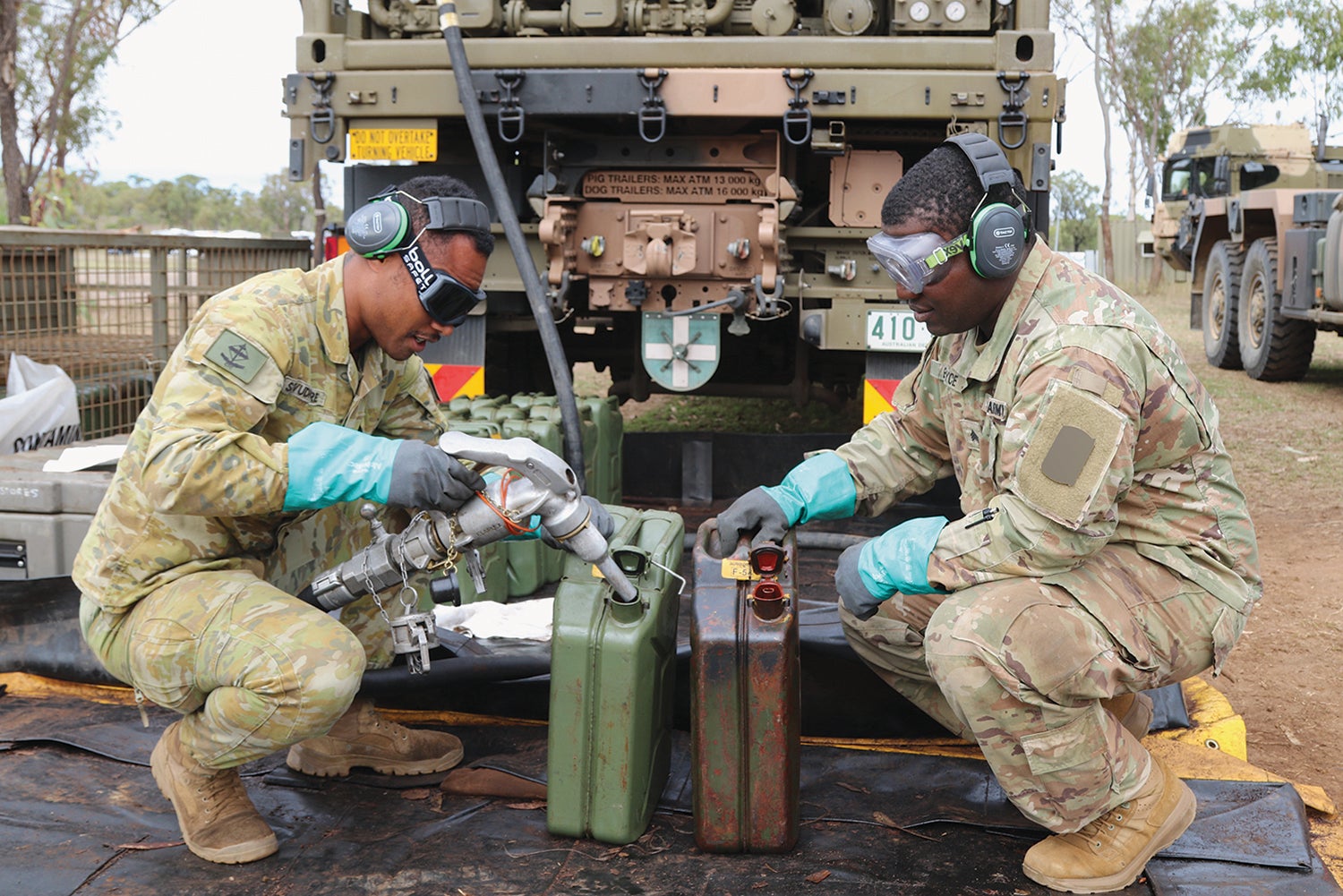 Lance Cpl. Iliesa Sevudredre, left, a truck driver and fueler with the Australian Defence Force, and Sgt. Craig Boyce, a UH-60 Black Hawk helicopter mechanic with the 25th Infantry Division, fill fuel cans in Queensland during Talisman Sabre. (Credit: U.S. Army/Spc. Richard Carlisi)