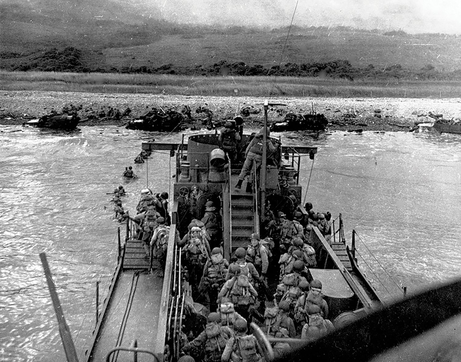U.S. soldiers disembark from a landing craft at Omaha Beach, Normandy, on D-Day. (Credit: National Archives)