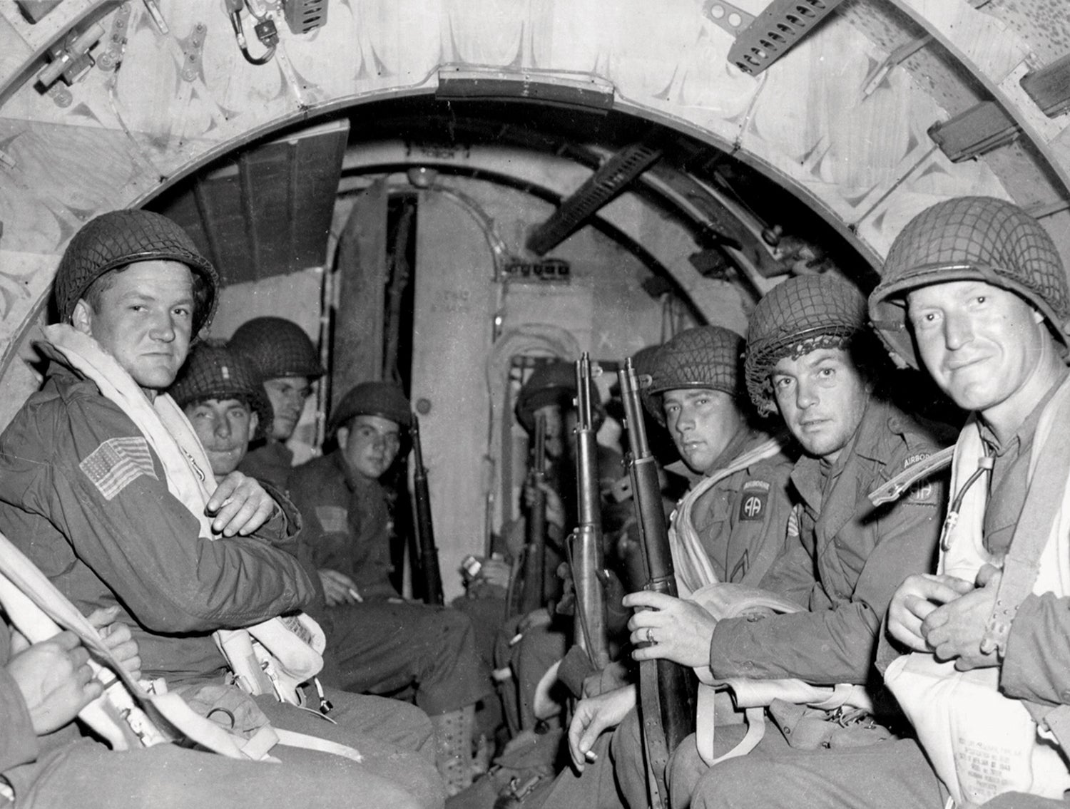 Left: Paratroopers aboard a C-47 transport plane on D-Day. (Credit: National Archives/U.S. Air Force)